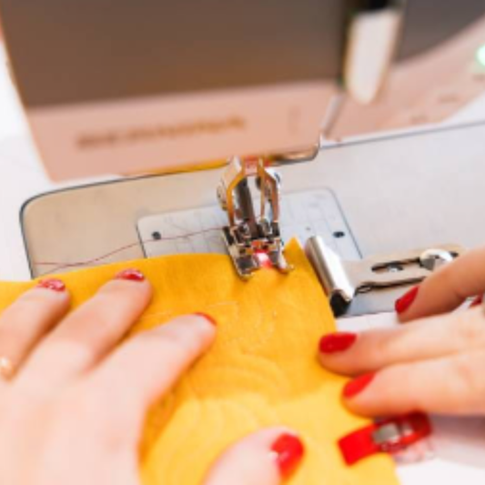 Machine_coudre_BERNINA_B770_pour_coudre_et_quiliter_broderie_avec_module_en_option Vue des mains et pied de biche prêt à coudre - tissu jaune